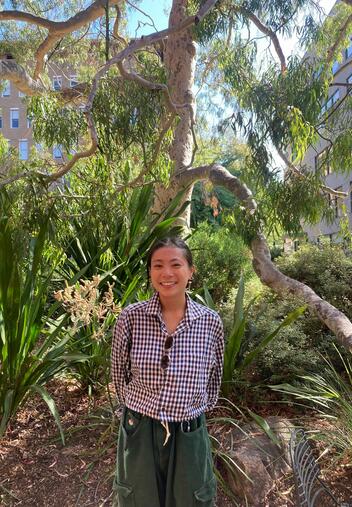 Image of young woman standing in front of a tree
